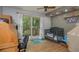 A cozy bedroom with a ceiling fan and a sliding glass door to a private balcony at 2279 Ranchette Ln, Dunedin, FL 34698