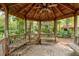 Interior view of a gazebo with benches and a ceiling fan, perfect for relaxing at 2279 Ranchette Ln, Dunedin, FL 34698
