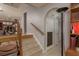 Hallway with tile floors, archway, and stairs leading to another level with wood railing and access to the kitchen at 2279 Ranchette Ln, Dunedin, FL 34698