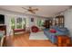 Bright living room with hardwood floors, comfortable seating, and large windows offering views of the landscaped yard at 2279 Ranchette Ln, Dunedin, FL 34698