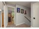 Staircase hallway with carpet and pictures on the wall, leading to a room with wood floors and exterior views at 2279 Ranchette Ln, Dunedin, FL 34698