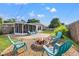 Backyard with a cozy fire pit area, seating, and an enclosed porch at 2701 65Th Ave S, St Petersburg, FL 33712