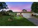 Charming home with a well-manicured front yard, lush landscaping, and a two-car garage, presenting an enchanting evening at 2701 65Th Ave S, St Petersburg, FL 33712