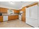 Functional kitchen features wood cabinets, tile floors, and white appliances, offering a practical space for cooking and meal preparation at 2701 65Th Ave S, St Petersburg, FL 33712