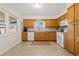 Bright kitchen with wooden cabinets, white appliances, and tile flooring at 2701 65Th Ave S, St Petersburg, FL 33712