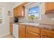 Close-up of kitchen sink with bright window, wood cabinets, and appliances at 2701 65Th Ave S, St Petersburg, FL 33712
