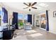 Sun-filled living room with ceiling fan, blue curtains, and glass doors at 2701 65Th Ave S, St Petersburg, FL 33712