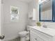 Clean white bathroom with a bright vanity, window, and blue mirror, offering a peaceful private area at 2713 Brianholly Dr, Valrico, FL 33596