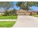 Charming home featuring a well-manicured lawn, mature trees, and a double-car garage at 2713 Brianholly Dr, Valrico, FL 33596