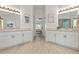 Well-lit bathroom with dual vanities, mirrors, and wood-look tile flooring leading to the bedroom, creating a spa-like retreat at 2713 Brianholly Dr, Valrico, FL 33596