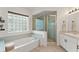 Clean bathroom featuring a soaking tub, separate shower, glass block window and neutral tones for a tranquil feel at 2713 Brianholly Dr, Valrico, FL 33596