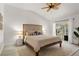 Serene main bedroom featuring a decorative headboard, ceiling fan, and sliding glass doors to the screened lanai at 2713 Brianholly Dr, Valrico, FL 33596