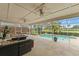 Inviting screened patio with a pool, ceiling fans, and comfortable seating, perfect for outdoor relaxation and entertaining at 2713 Brianholly Dr, Valrico, FL 33596