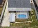 Aerial view of the home and backyard featuring screened-in pool, patio, shed, and fenced yard at 3104 Apricot St, Seffner, FL 33584