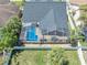 An aerial view showcasing the home's pool and screened-in patio within a fenced yard, enhancing outdoor living at 332 Wood Dove Ave, Tarpon Springs, FL 34689