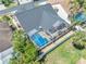 Aerial view of a home showcasing the screened-in pool, lush landscaping, and well-maintained backyard at 332 Wood Dove Ave, Tarpon Springs, FL 34689