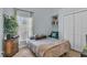Cozy bedroom with wood floors, a window with curtains, and ample storage with closet and shelving at 332 Wood Dove Ave, Tarpon Springs, FL 34689