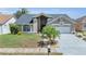 Charming single Gathering home boasting mature landscaping, a two-car garage, and inviting curb appeal at 332 Wood Dove Ave, Tarpon Springs, FL 34689