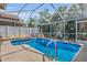 Relaxing screened-in pool with lush tropical landscaping and a waterfall feature, perfect for a tranquil retreat at 332 Wood Dove Ave, Tarpon Springs, FL 34689