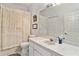 Bright bathroom features a large mirror, white cabinets, and a shower with a floral curtain at 35229 Janine Dr, Zephyrhills, FL 33541