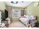 Cozy bedroom has a window, decorative flower wall decor, and comfy furnishings at 35229 Janine Dr, Zephyrhills, FL 33541