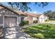 Exterior shot of home with green lawn, driveway, and attached one-car garage at 35229 Janine Dr, Zephyrhills, FL 33541