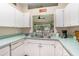 Bright kitchen features white cabinetry and a large opening for natural light at 35229 Janine Dr, Zephyrhills, FL 33541