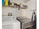 Functional laundry area features a washer, dryer, shelving, and an ironing board at 35229 Janine Dr, Zephyrhills, FL 33541