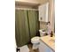 The bathroom features a shower with a decorative green shower curtain and a toilet at 3615 Pine Knot Dr, Valrico, FL 33596