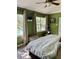 Comfortable bedroom provides two large windows with lots of natural light and calming green walls at 3615 Pine Knot Dr, Valrico, FL 33596