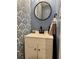 Charming half bath with stylish wallpaper, modern vanity, and elegant round mirror at 3615 Pine Knot Dr, Valrico, FL 33596