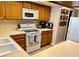 Open kitchen featuring light countertops, ample oak cabinetry, and modern white appliances at 3615 Pine Knot Dr, Valrico, FL 33596