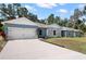 Charming home showcasing a well-maintained lawn, attractive stone accents, and a welcoming driveway at 37230 Poinsettia Ave, Dade City, FL 33525