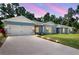 Charming single-story home showcasing stone accents, a well-manicured lawn, and an inviting two-car garage at 37230 Poinsettia Ave, Dade City, FL 33525