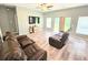 Relaxing living room with wood floors, ceiling fan, and sliding doors to the backyard at 37230 Poinsettia Ave, Dade City, FL 33525