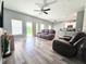 Bright living room with sliding door, ceiling fan, wood floors, and open layout at 37230 Poinsettia Ave, Dade City, FL 33525