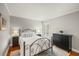 Comfortable bedroom featuring an iron bed frame, wood floors, neutral walls, and natural light from the window at 3922 Cedar Cay Circle, Valrico, FL 33596