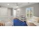 Bright Bedroom with plantation shutters, hardwood floors, white crib, a glider chair, and ample closet space at 3922 Cedar Cay Circle, Valrico, FL 33596