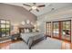 Bright main bedroom features a vaulted ceiling, ceiling fan, and French doors to the screened patio at 3922 Cedar Cay Circle, Valrico, FL 33596