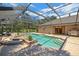 An in-ground screened pool and spa with lush landscaping, and an outdoor kitchen at 3922 Cedar Cay Circle, Valrico, FL 33596