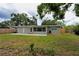 A spacious backyard featuring a patio, lush green lawn, and mature trees, providing a serene outdoor living space at 4105 W Oakellar Ave, Tampa, FL 33611