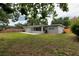 Expansive backyard featuring a well-manicured lawn, patio, and mature trees for shade at 4105 W Oakellar Ave, Tampa, FL 33611