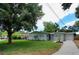 Lovely home featuring green lawn, mature trees, and a long driveway leading to an attached garage at 4105 W Oakellar Ave, Tampa, FL 33611