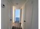 Bright hallway with wood-look flooring and white doors leading to different areas of the home at 4105 W Oakellar Ave, Tampa, FL 33611