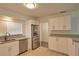 Well-lit kitchen featuring white cabinetry, granite countertops, and stainless steel appliances at 4105 W Oakellar Ave, Tampa, FL 33611