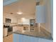 Bright kitchen featuring white cabinetry, granite countertops, and stainless steel appliances at 4105 W Oakellar Ave, Tampa, FL 33611