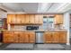 Kitchen features stainless steel appliances, a large window, wood cabinets, and durable tile flooring at 414 Cactus Cir, Seffner, FL 33584