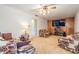 Spacious living room with plush carpet, wood paneling, ceiling fan and comfortable furniture, perfect for relaxation at 414 Cactus Cir, Seffner, FL 33584