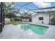 Inviting screened pool with patio, perfect for relaxing and entertaining, next to a white block home and outbuildings at 414 Cactus Cir, Seffner, FL 33584