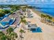 Panoramic aerial view of the sandy beach, picnic shelters, and clear blue waters, a great spot for relaxation at 4408 Rudder Way, New Port Richey, FL 34652